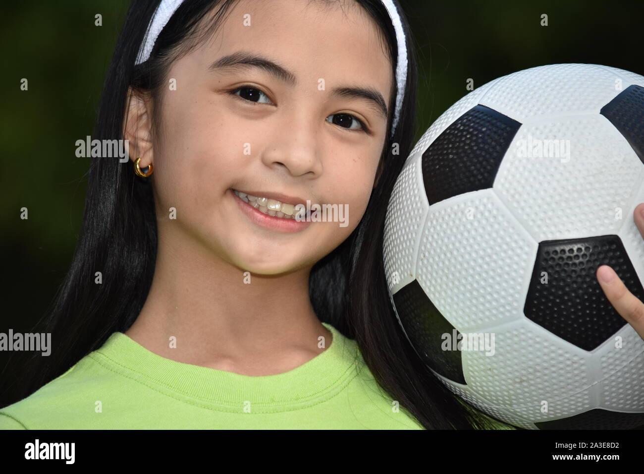 Sportliche asiatische Kind Fußball-Spieler lächelnd mit Fußball Stockfoto
