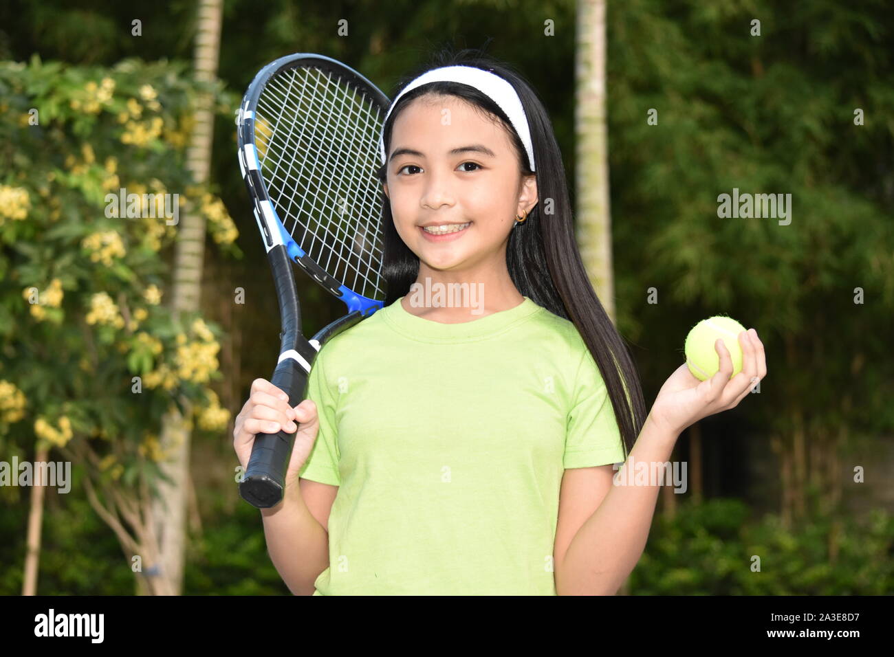Glückliches Kind weiblichen Athleten mit Tennisschläger Stockfoto