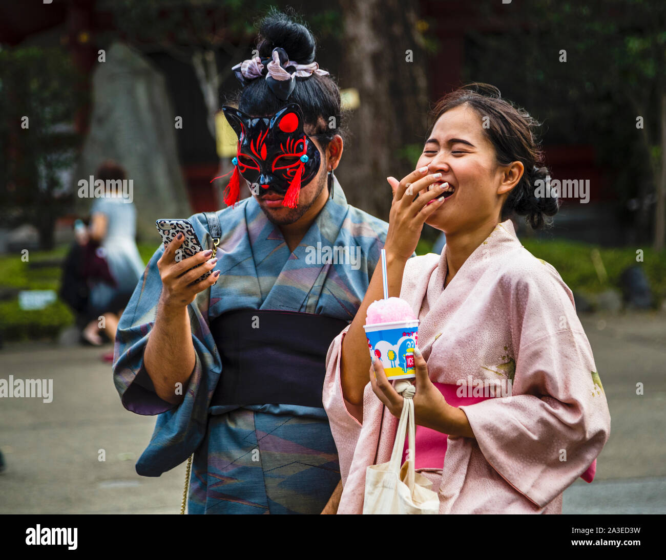 Bizarre Situation: kimono trägt ein maskiertes Paar. Straßenleben in Tokio, Japan Stockfoto
