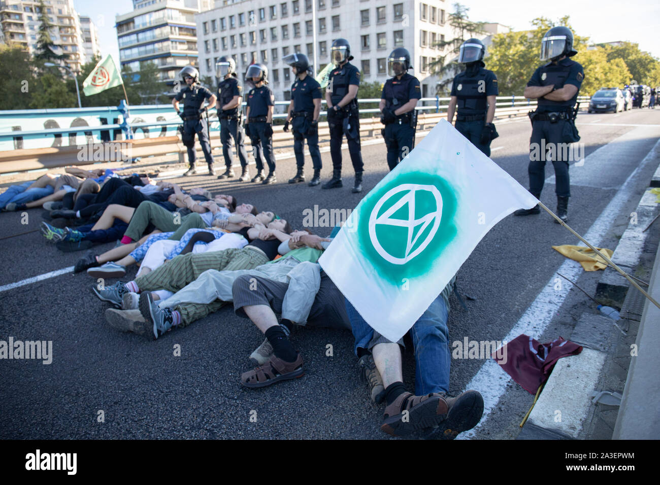 Aktivistinnen in eine passive und Pazifik Widerstand vor der Polizei während des Protestes. Städte weltweit wie London, Berlin, New York, Buenos Aires, París das zweite Internationale Woche Rebellion gestartet wird, während Aktivistinnen in verschiedenen Aktionen von Pacific Proteste und zivilen Ungehorsams unter der ethischen Verpflichtung führen Sie die Verantwortung einer politischen Aktion für die Zwecke der schwerwiegenden Folgen des Klimawandels und der ökologischen Auswirkungen abzuschwächen, zurückzufordern. In Madrid wurden zwei parallele Aktionen, eine in "Paseo de la Castellana", wo eine Hauptstraße für eine Menschenkette blockiert war und es gab einige Akt Stockfoto