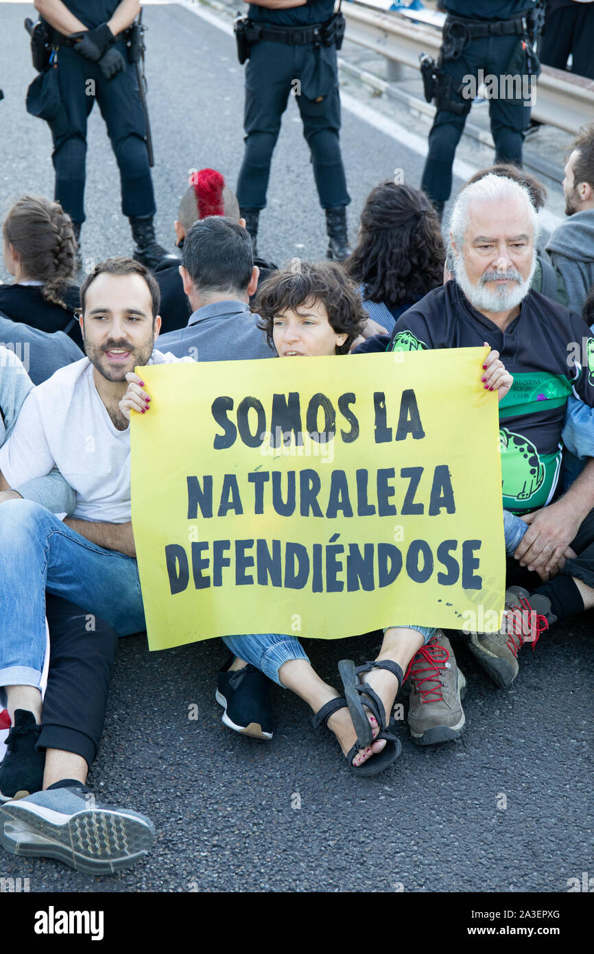Eine Gruppe von Demonstranten halten ein Banner, die besagt, dass wir die Natur in der Verteidigung sind während des Protestes. Städte weltweit wie London, Berlin, New York, Buenos Aires, París das zweite Internationale Woche Rebellion gestartet wird, während Aktivistinnen in verschiedenen Aktionen von Pacific Proteste und zivilen Ungehorsams unter der ethischen Verpflichtung führen Sie die Verantwortung einer politischen Aktion für die Zwecke der schwerwiegenden Folgen des Klimawandels und der ökologischen Auswirkungen abzuschwächen, zurückzufordern. In Madrid wurden zwei parallele Aktionen, eine in "Paseo de la Castellana", wo eine Hauptstraße für eine Menschenkette blockiert wurde, und es gab so Stockfoto