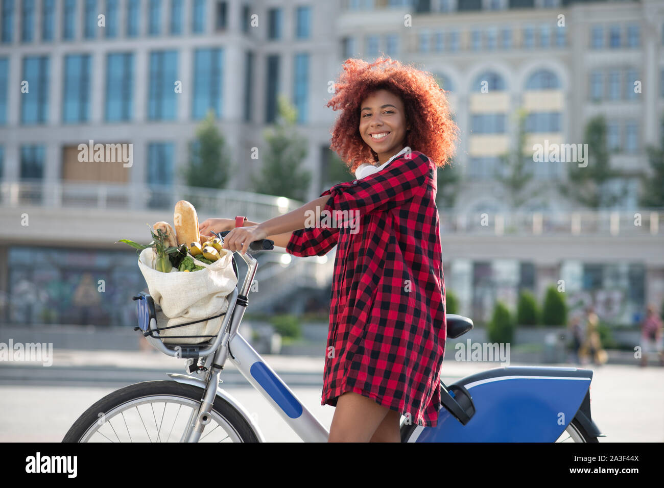 Fröhliche curly Frau Gefühl glücklich nach dem Kauf von Lebensmitteln Stockfoto