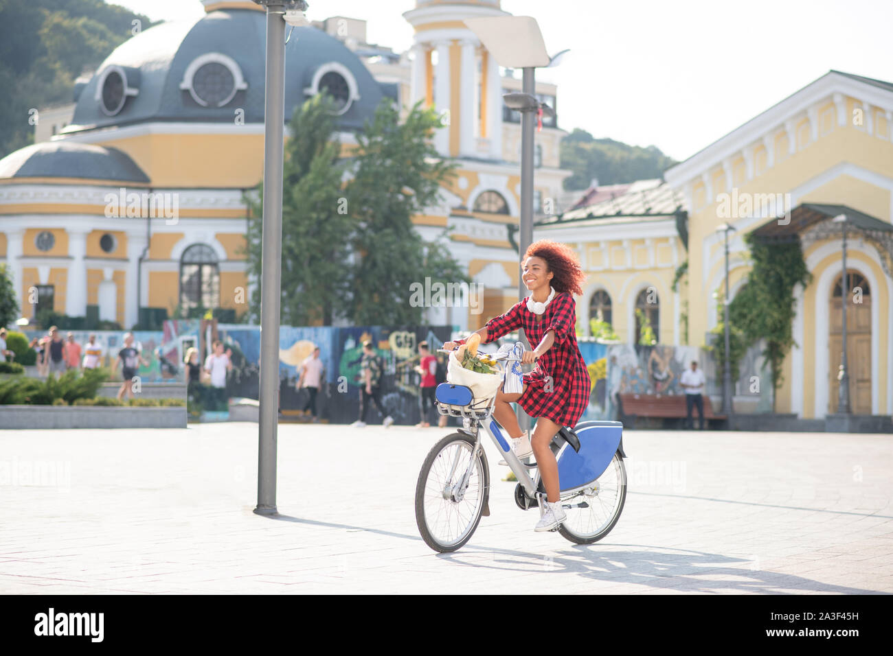 Curly Rothaarige student Reiten Fahrrad auf warmen sonnigen Tag Stockfoto