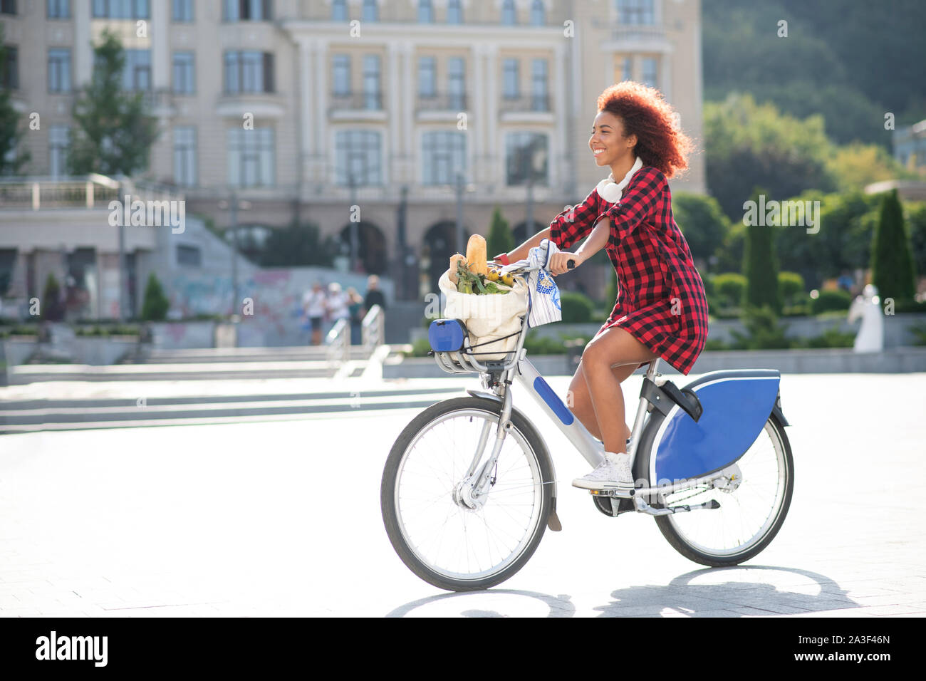 Curly rothaarige Frau Reiten Fahrrad nach zum Supermarkt gehen Stockfoto