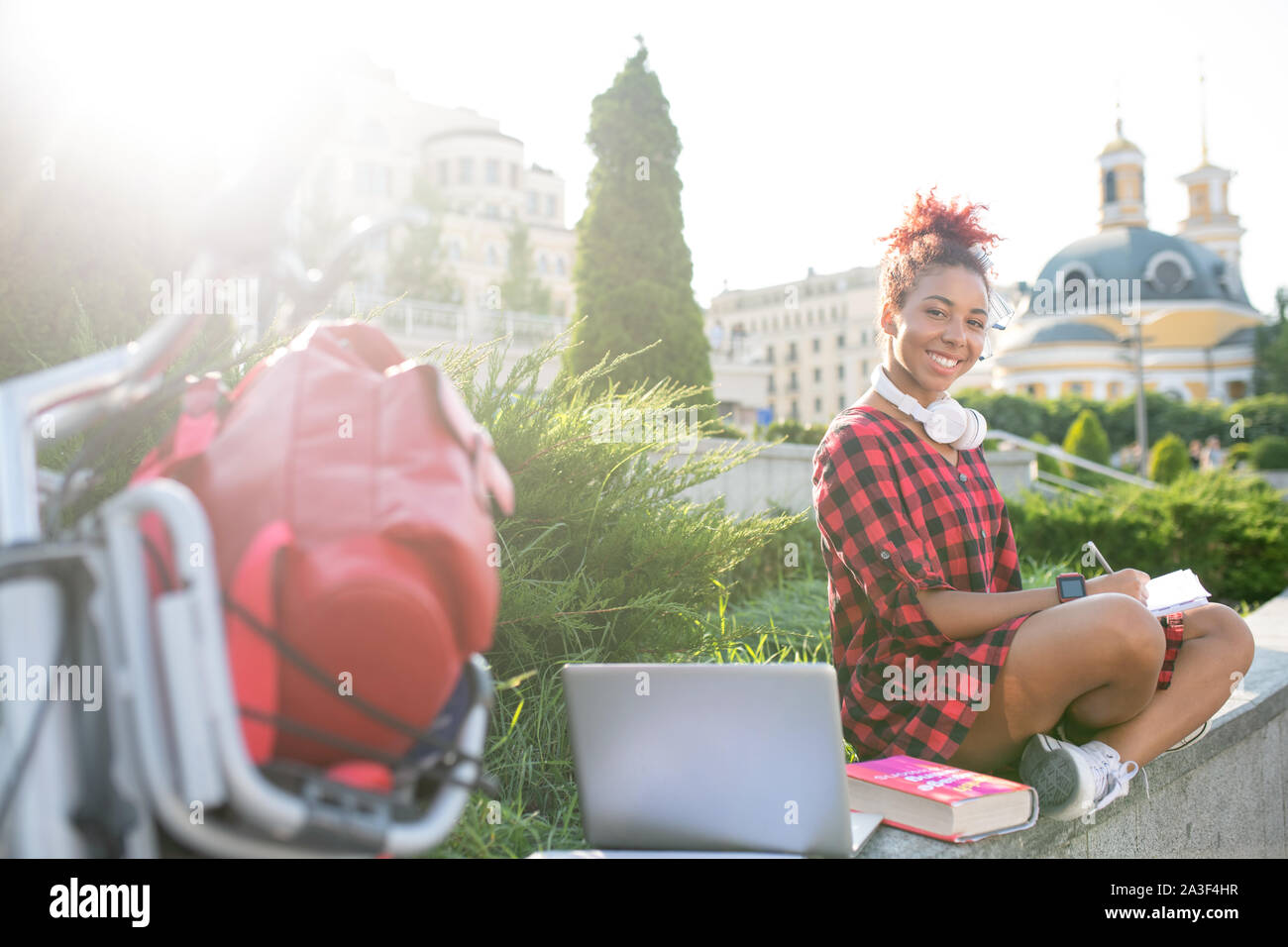 Student Studium außerhalb mit Laptop und Bücher Stockfoto