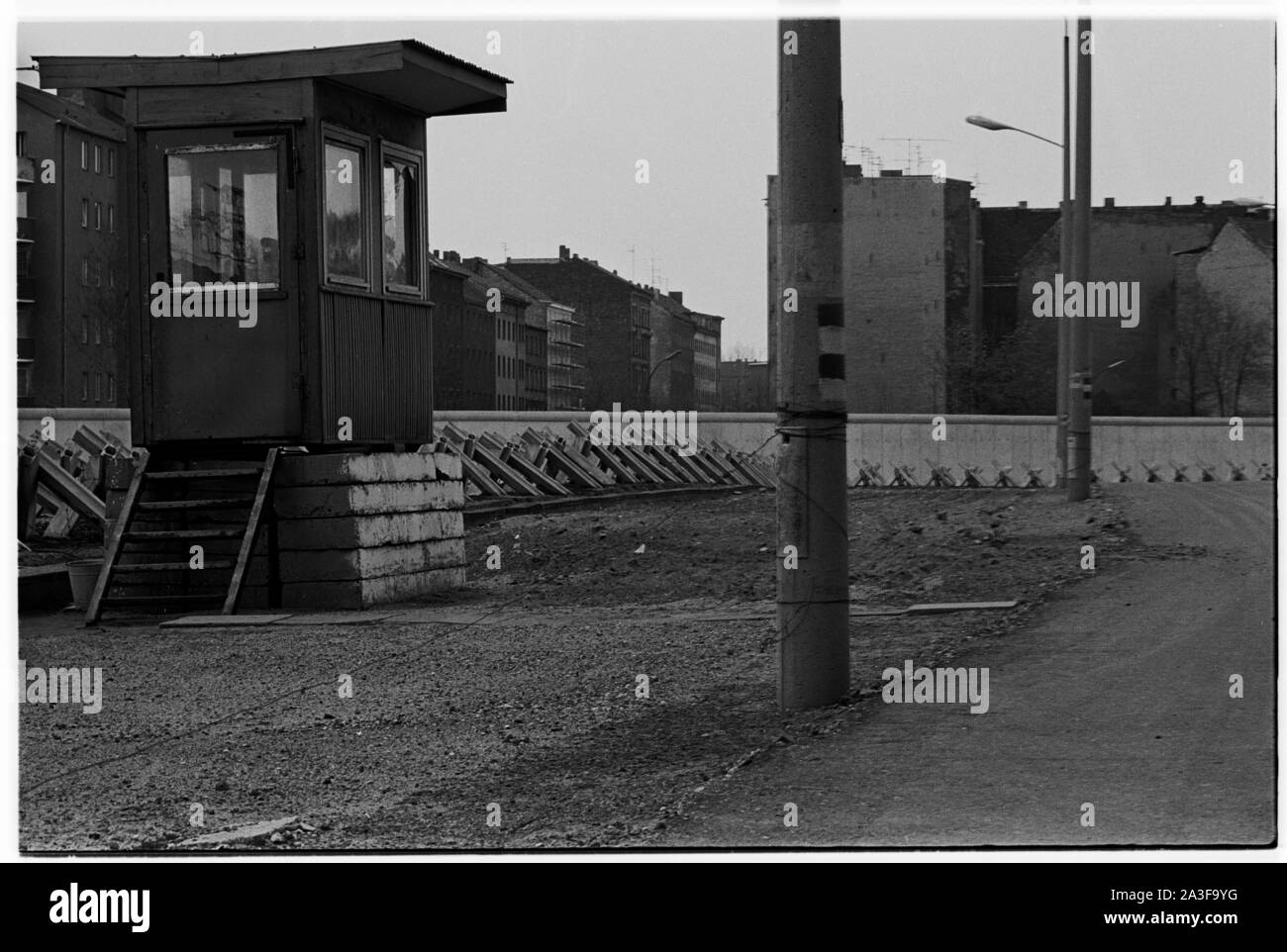 Blick auf die Berliner Mauer aus Ost-Berlin in der Freirichstraße mit geracktem Sand, Panzerfallen und Schutzhütte. Stockfoto