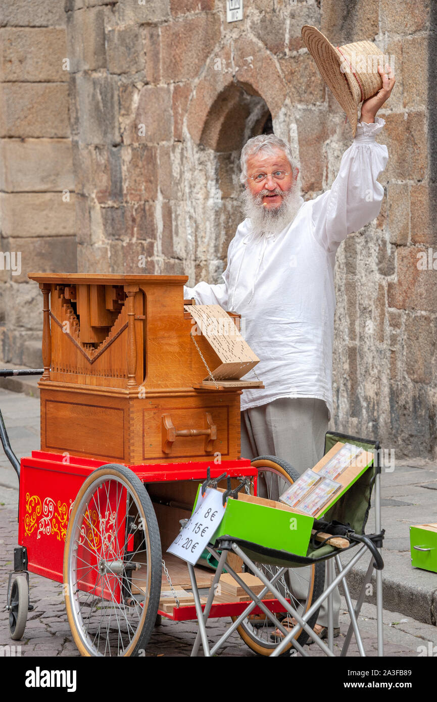 Saint-Malo, Frankreich - 20. Juli 2017: Alter Mann mit langen weißen Brot steht hinter seiner Straße Orgel singen, während sein Musikinstrument für Tipps. Stockfoto
