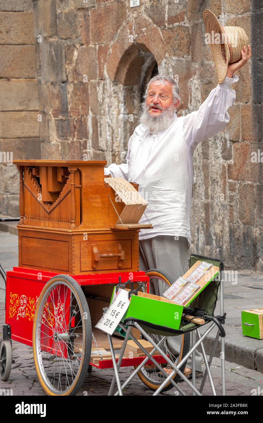 Saint-Malo, Frankreich - 20. Juli 2017: Alter Mann mit langen weißen Brot steht hinter seiner Straße Orgel singen, während sein Musikinstrument für Tipps. Stockfoto