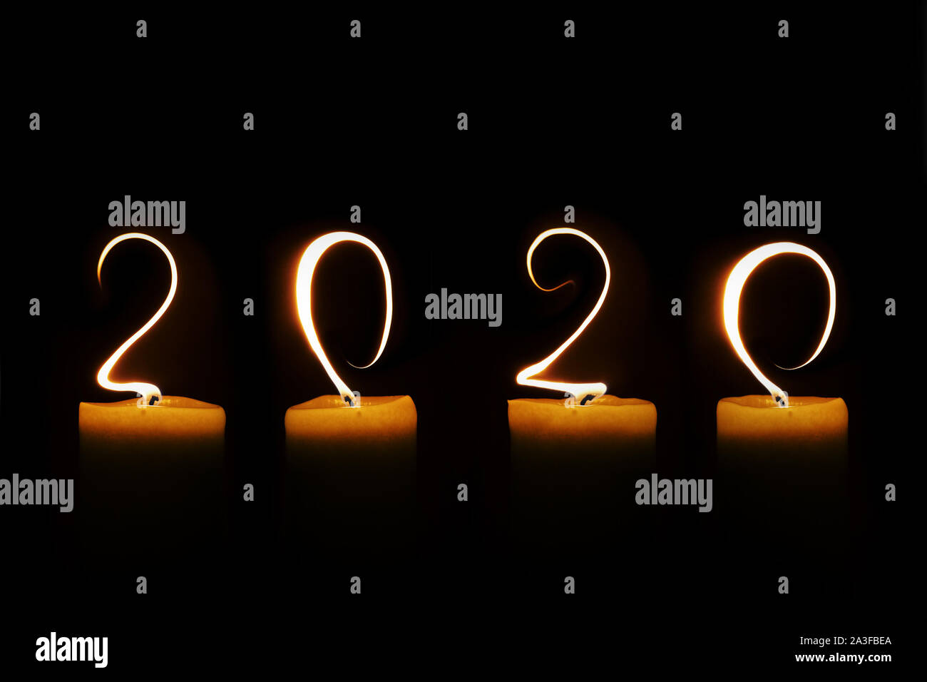 2020 mit Kerze Flammen auf schwarzem Hintergrund geschrieben, Grußkarte Stockfoto