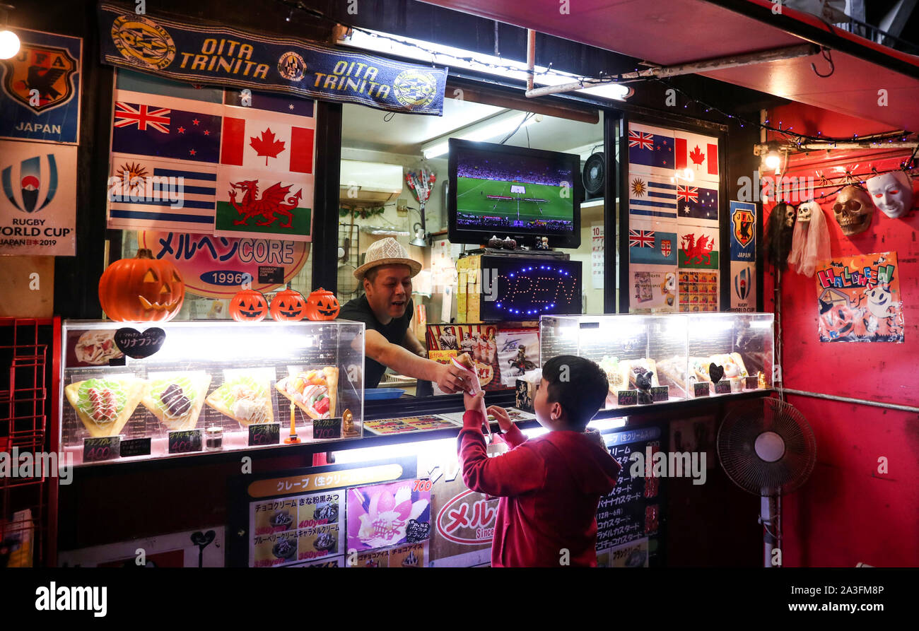 Ein kleiner Junge wartet auf seine Krepp in einem Stall in Oita, wie Er beobachtet den Start von Südafrika v Kanada in den Rugby World Cup. Stockfoto