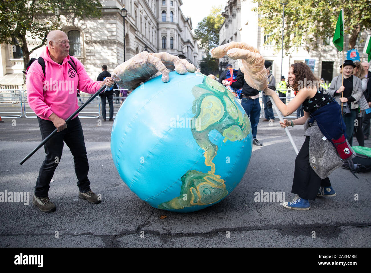 Die Demonstranten mit einem riesigen aufblasbaren Erde während eines Aussterben Rebellion (XR) Protest auf Whitehall in Westminster, London. Stockfoto
