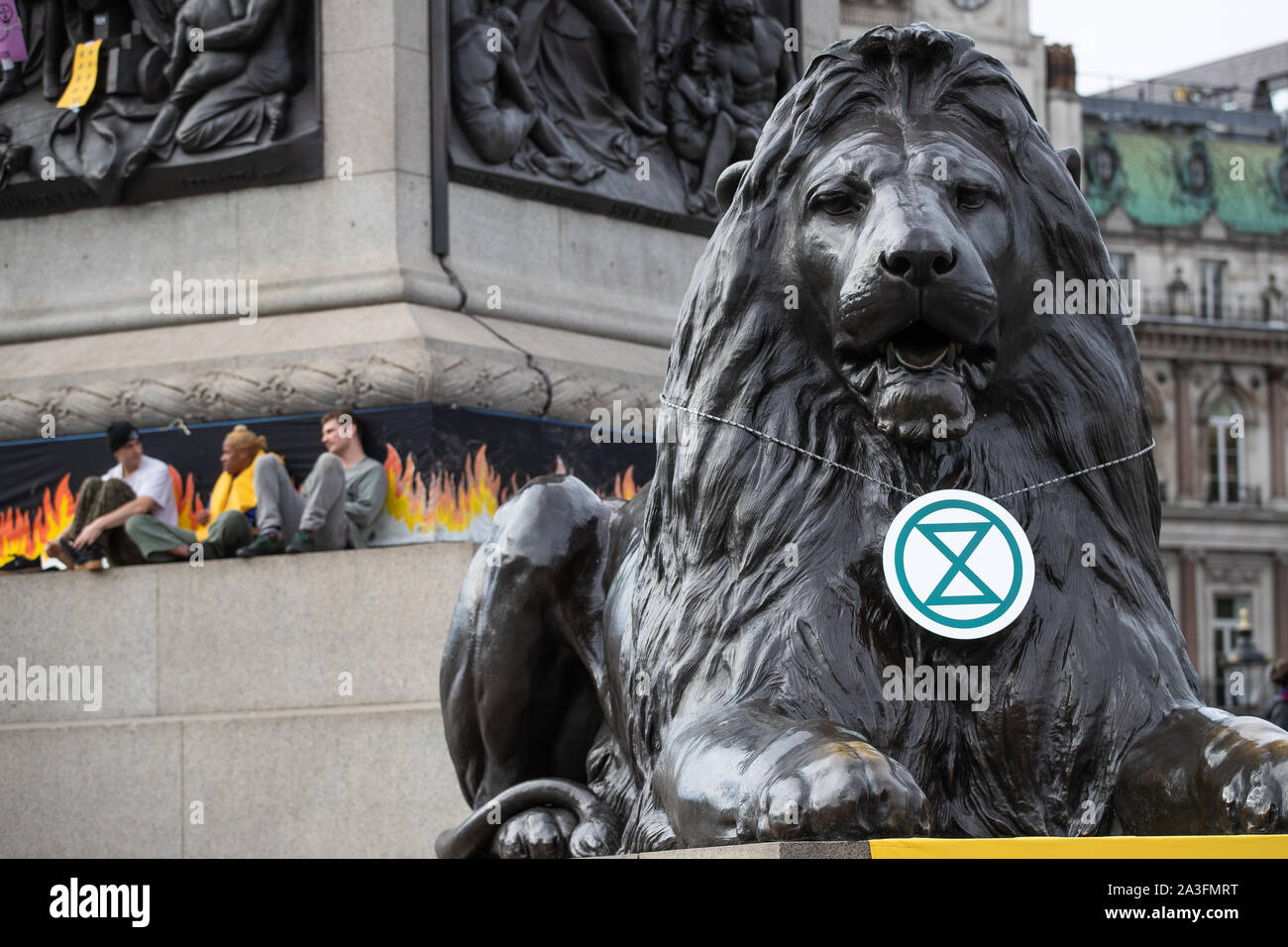 Ein Banner drapierten über einem Der Landseer Lions während eines Aussterben Rebellion (XR) Protest in Trafalgar Square in London. Stockfoto