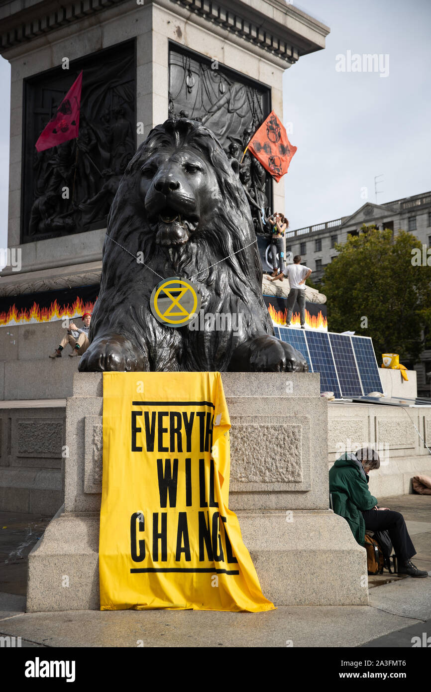 Ein Banner drapierten über einem Der Landseer Lions während eines Aussterben Rebellion (XR) Protest in Trafalgar Square in London. Stockfoto