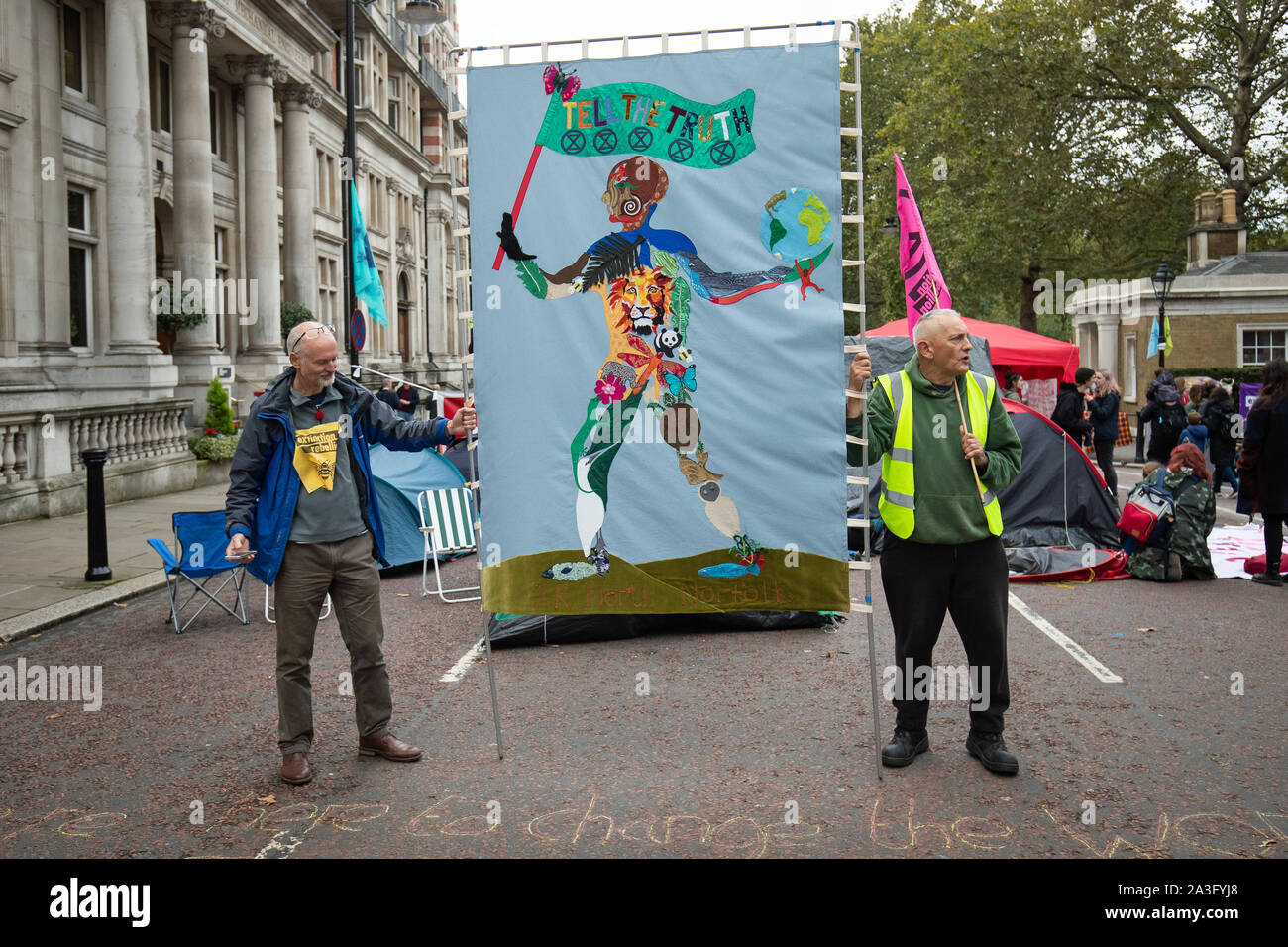 Die Demonstranten halten das Plakat an der Kreuzung zwischen Horse Guards Road und Vogelkäfige gehen, während ein Aussterben Rebellion (XR) Protest in Westminster, London. Stockfoto