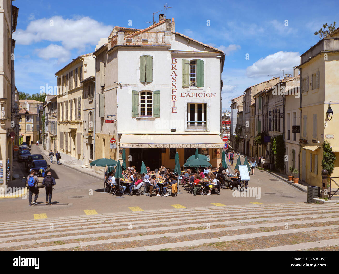 Cafe Brasserie l'Aficion mit einem vollen außerhalb Terrasse an der Unterseite der Treppe im Zentrum von Arles, Frankreich zur Mittagszeit Stockfoto