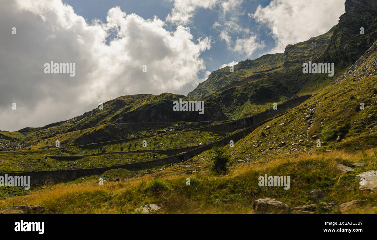 Spektakuläre Aussicht auf die berühmte Transfagarasan Pass windet sich durch Fagaras Gebirge und flauschige Wolken an einem Sommertag, Rumänien Stockfoto