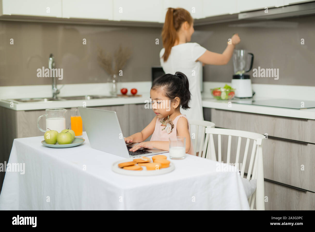 Gerne asiatische Familie essen Frühstück und siehe Digitale Tablet in der Küche zu Hause. Gesundes Essen und Morgen Aktivitäten Stockfoto