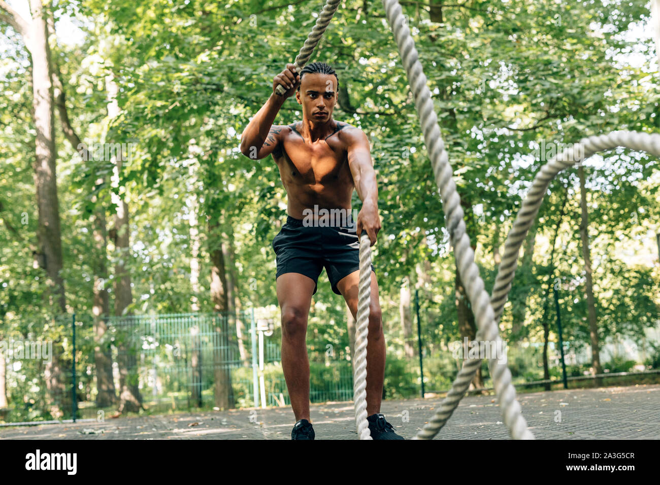 Mann tun Fitness Workout mit Kämpfen Seil am Sportplatz Stockfoto