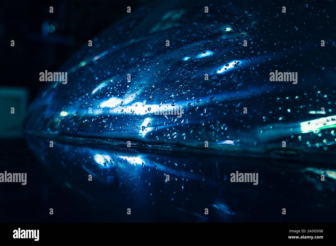 Blau Reflexionen und Regentropfen auf nassen Auto Haube. Abstrakte Nacht Stadt Hintergrund Foto Stockfoto