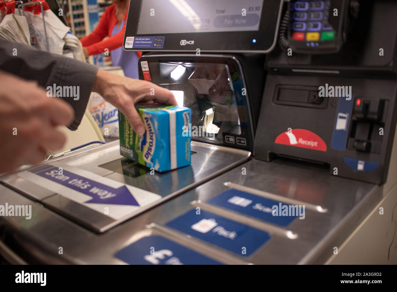 Frau Scannen eines Artikels in einem self service bis in einem Supermarkt. Diese Maschinen bieten einen Mechanismus für Kunden, die ihre eigenen Einkäufe zu verarbeiten Stockfoto