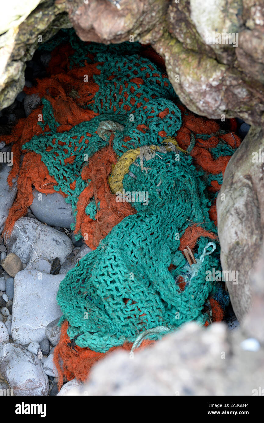 Grün und Orange Fischernetz angeschwemmte zwischen Felsen auf Gower Stockfoto