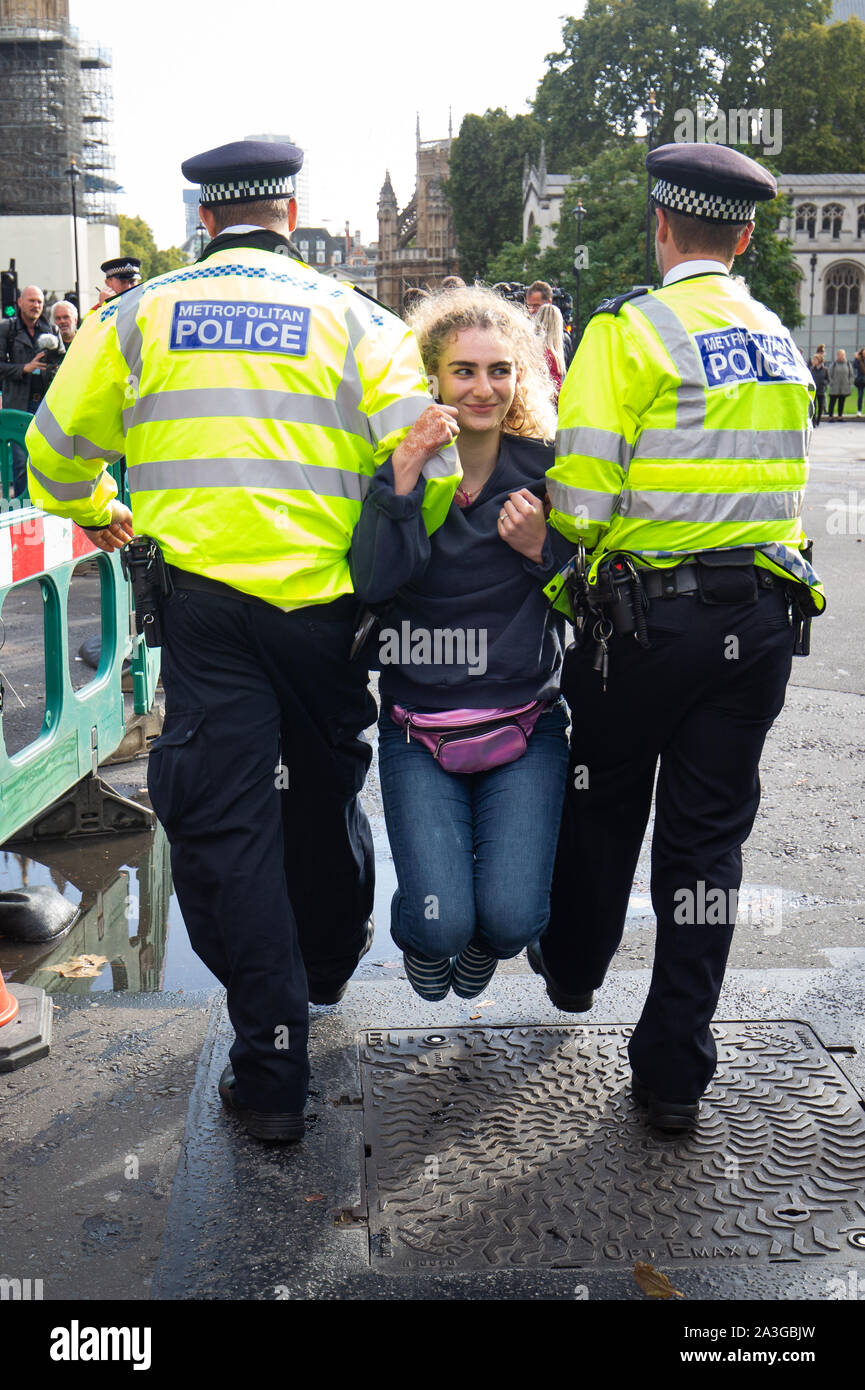 Die Polizei einen Demonstrator während eines Aussterben Rebellion (XR) Protest in Westminster, London entfernen. Stockfoto