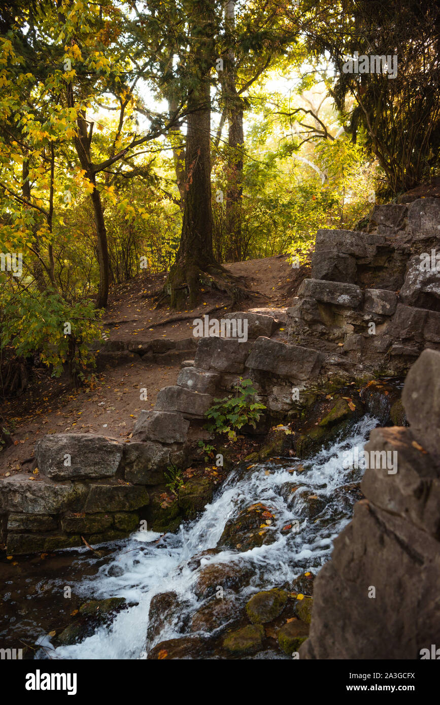 Sanft fließende Bäche, langsam wirbelnde Pools und malerische Wasserfälle schaffen eine ruhige Herbstszene im Victoria Park, Berlin Stockfoto