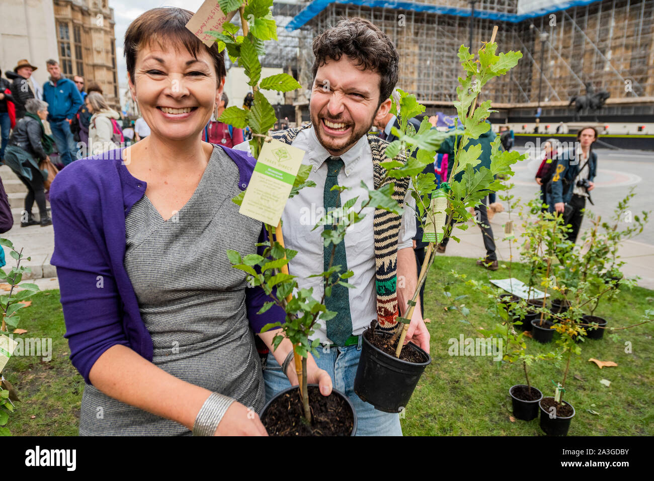 London, Großbritannien. 8. Oktober, 2019. Caroline Lucas, Grün MP, sammelt Ihr Baum von einem der Organisatoren - Bäume für jedes Mitglied des Parlaments mit ihren Telefonnummern auf so Inhaltsstoffe fragen Sie können unten zu kommen und Sie sammeln - Aussterben Rebellion sind nun in den zweiten Tag ihres Oktober Aktion die blockieren Straßen im Zentrum Londons für bis zu zwei Wochen verlegt werden. Sie sind einmal hervorheben, das Klima, mit der Zeit den Planeten vor einer Klimakatastrophe zu speichern. Credit: Guy Bell/Alamy leben Nachrichten Stockfoto