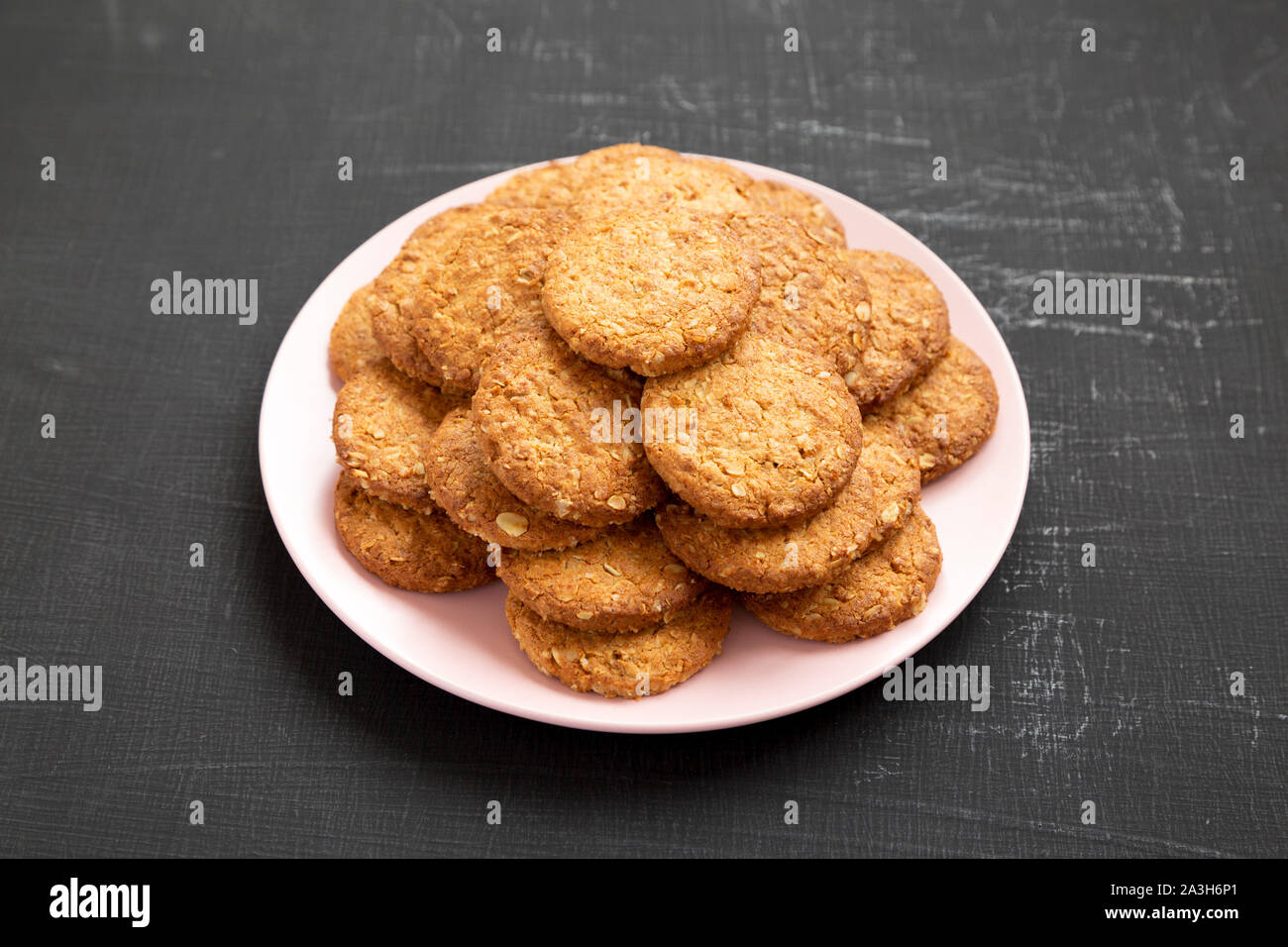 Cornflakes Cookies auf ein rosa Platte auf eine schwarze Fläche, Seitenansicht. Nahaufnahme. Stockfoto