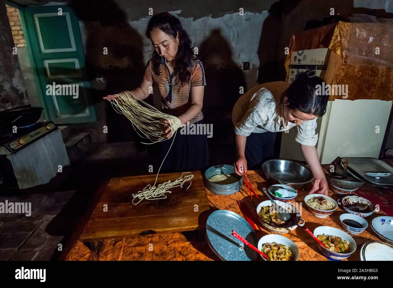 China, Xinjiang autonome Region, Kashgar, in einem Uigurischen Familie, die Vorbereitung der hausgemachte Nudeln, für das nationale Gericht auf der Basis von Nudeln, Hammel Fleisch und Gemüse Stockfoto