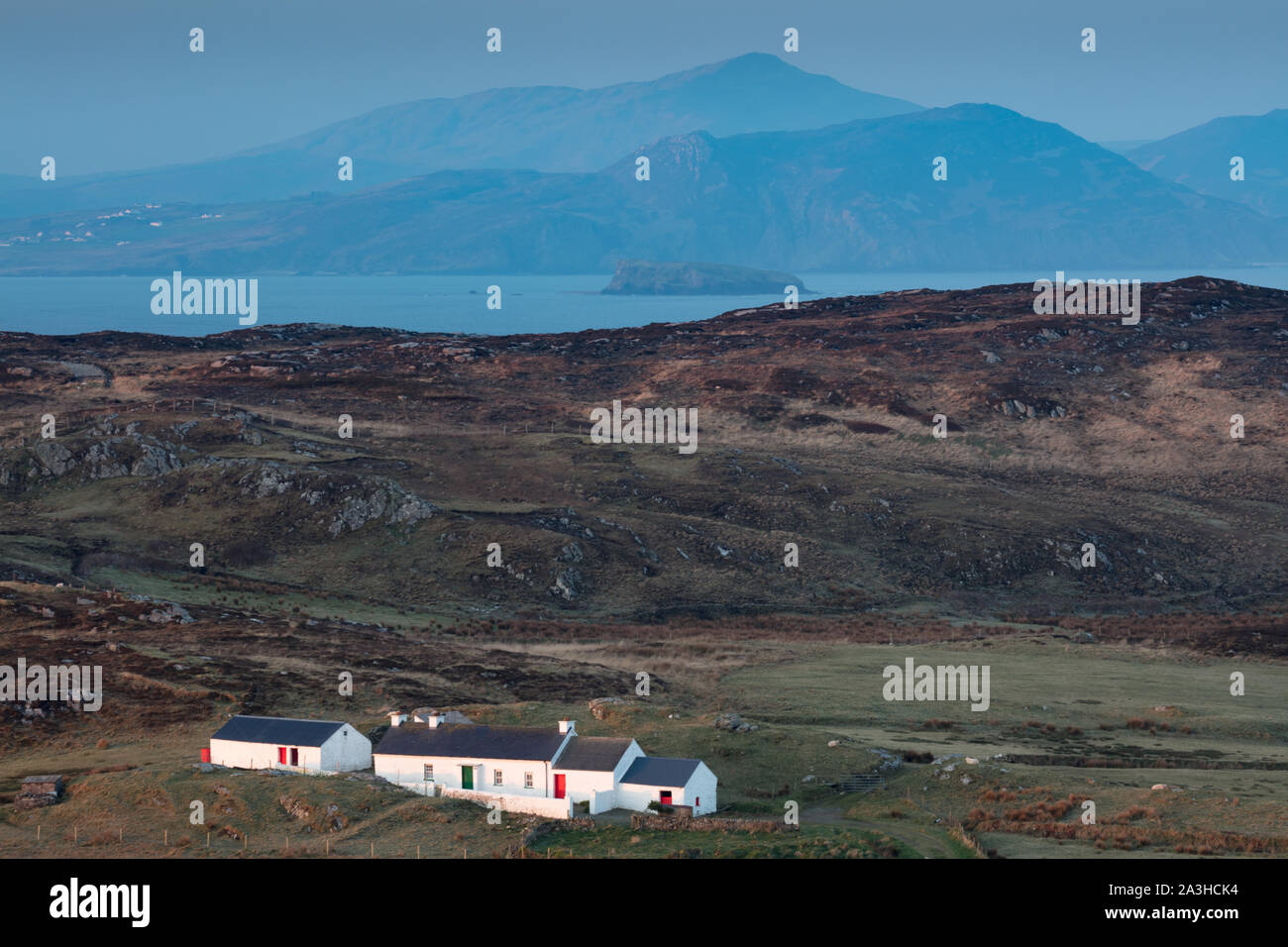 Ein Häuschen auf Malin Head in der Dämmerung mit Dunaff Kopf jenseits, Halbinsel Inishowen, Co Donegal, Irland Stockfoto