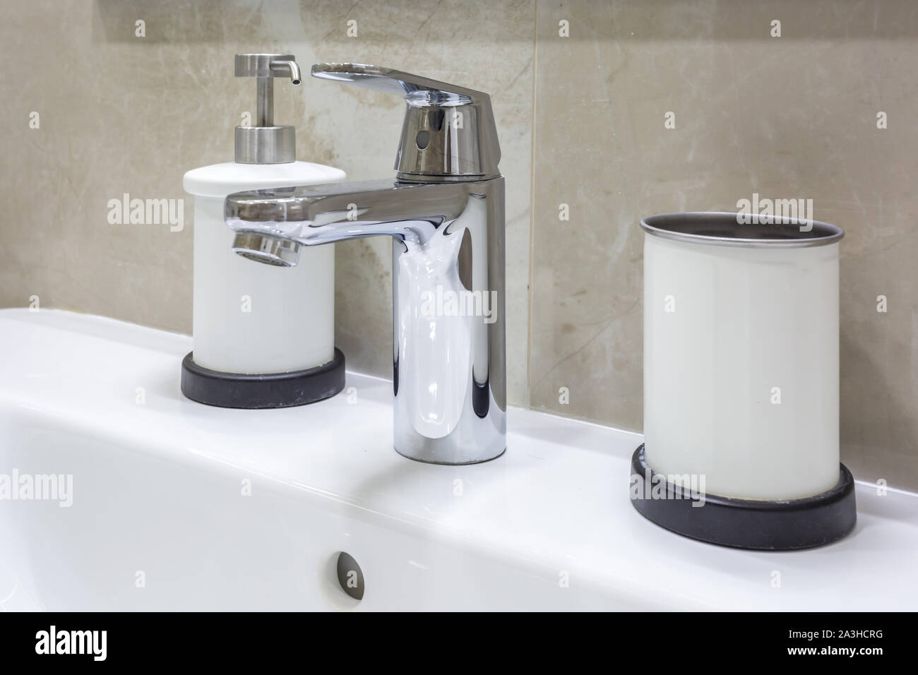 Seifen- und Shampoospender in der Nähe von keramischen Wasser Waschbecken mit Wasserhahn in teuren loft Bad tippen Stockfoto
