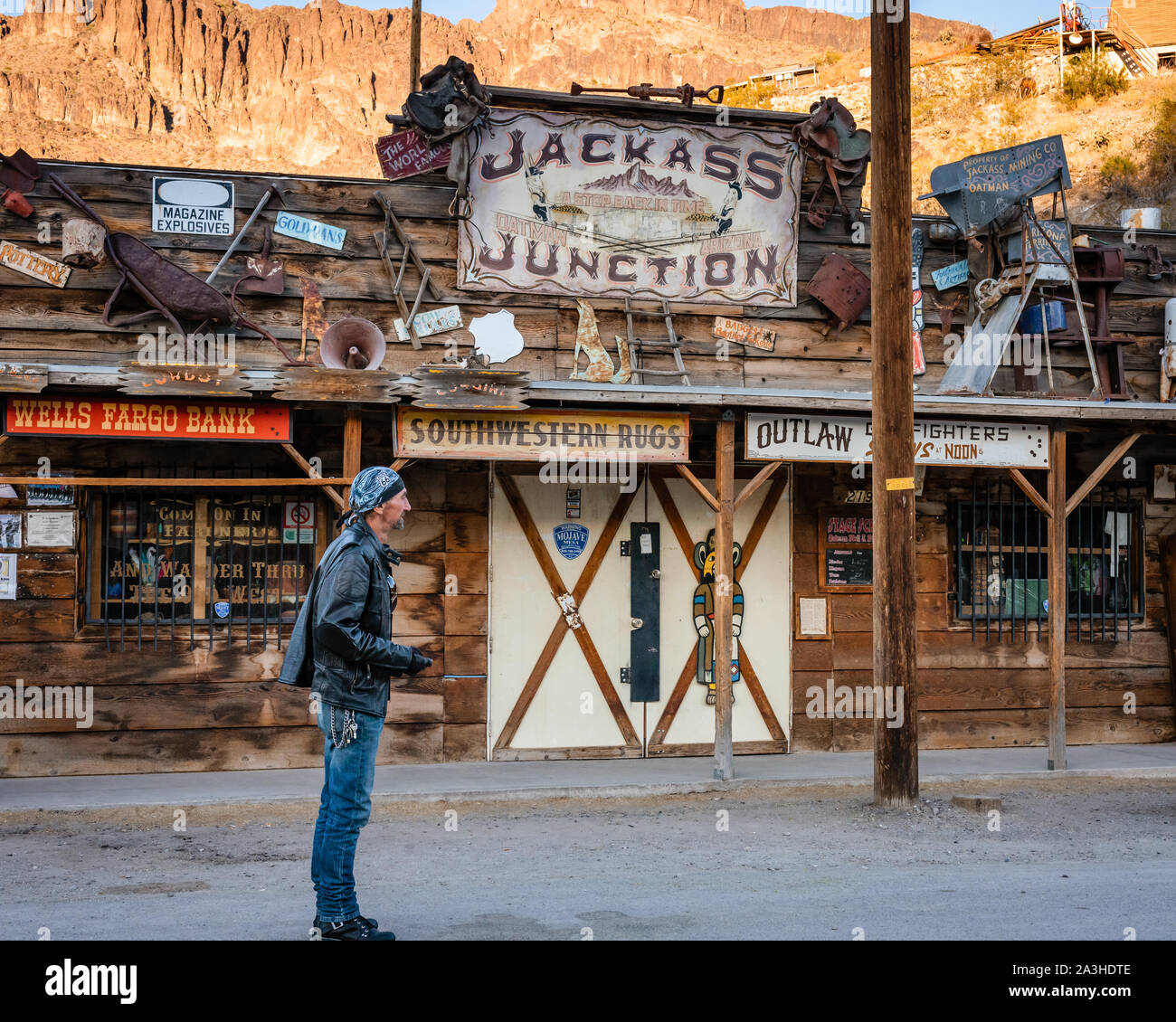 Eine alte Biker trägt eine Lederjacke und Biker Kleidung steht auf der Straße vor einem Geschäft in Oatman, Arizona. Stockfoto