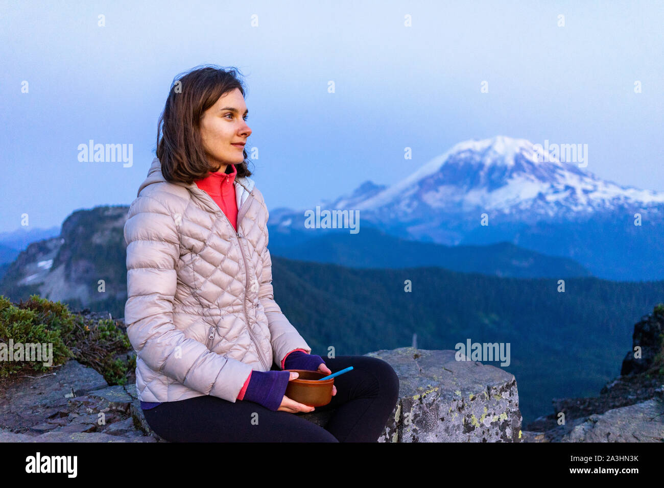 Frau Wanderer ist Essen Abendessen mit Mount Rainier im Hintergrund Stockfoto