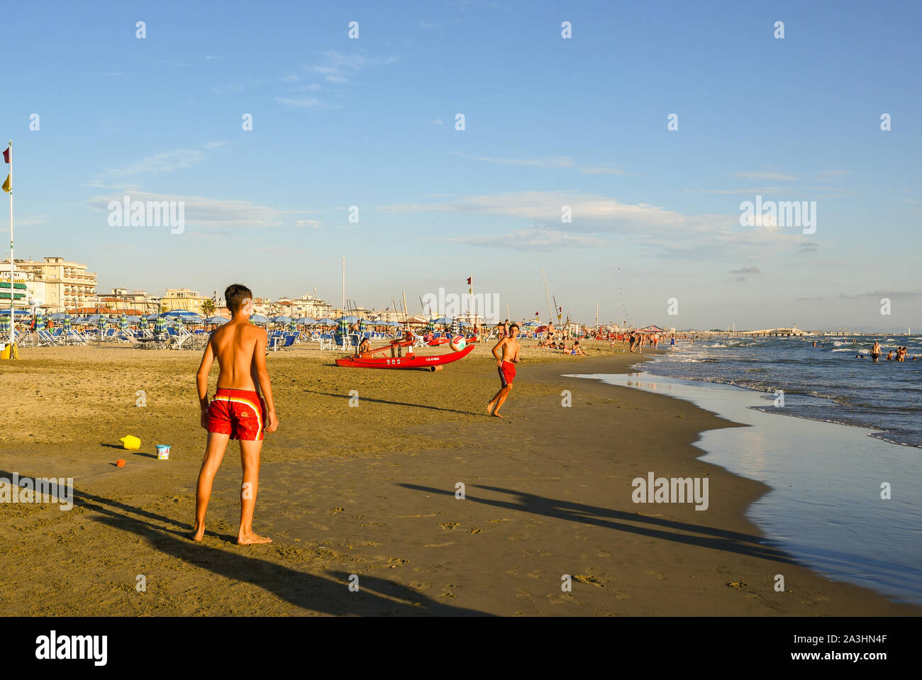 Zwei Teenager Ball spielen, der am Ufer des Meeres der Sandstrand von Lido di Camaiore, einem beliebten Reiseziel auf die Küste der Versilia, Toskana, Italien Stockfoto