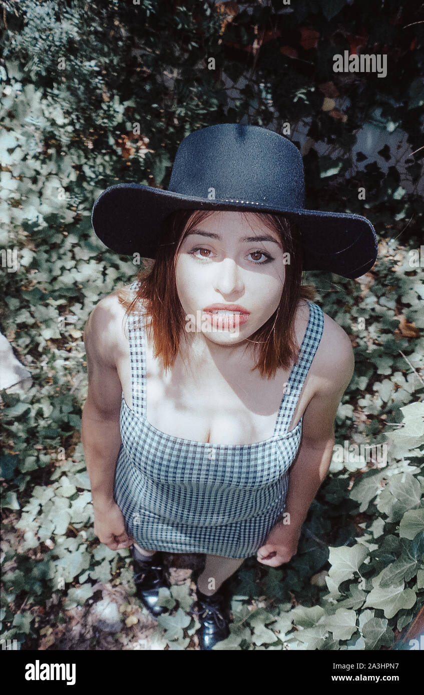 Latin Frau mit Hut und karierten kleid mit Kamera in den Wald. Stockfoto