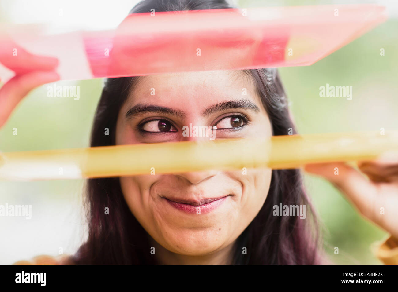 Junge Frau außerhalb lächelnd Haltebleche Stockfoto