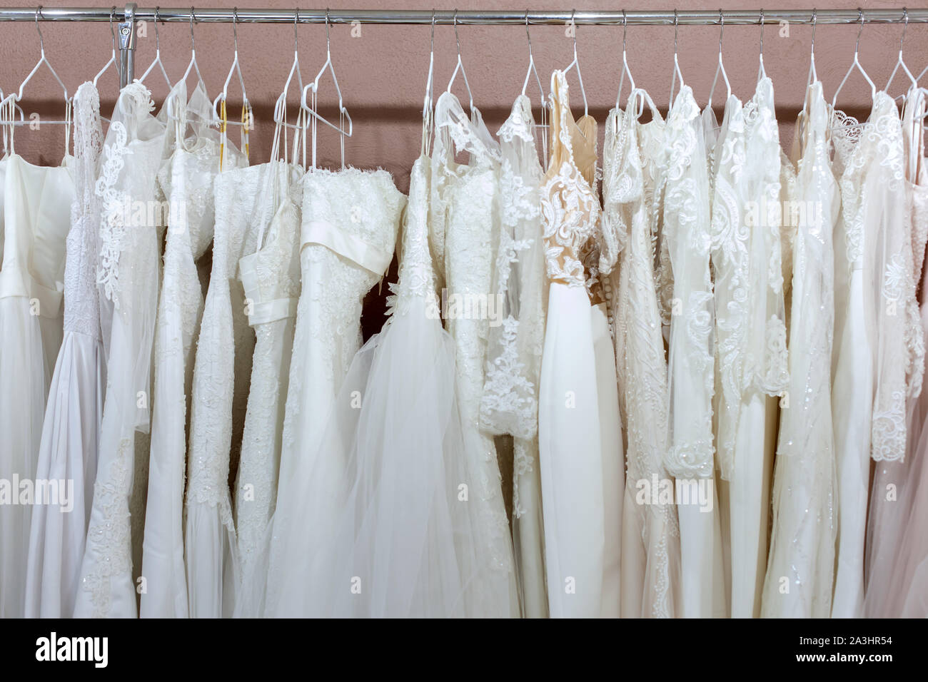 Schöne weiße Brautkleider hängen auf der Zähler im Bridal Salon. Stockfoto
