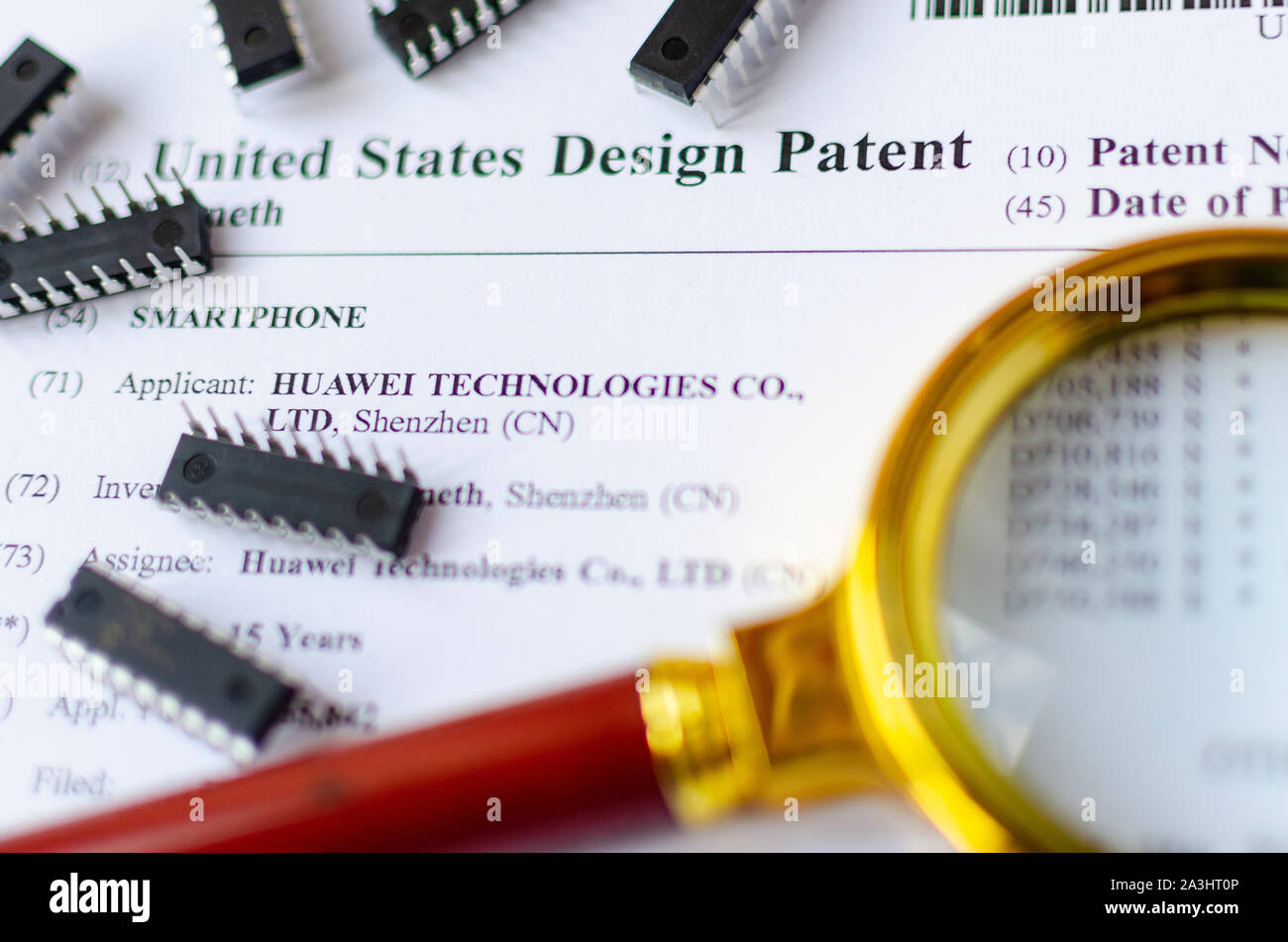 Die Nahaufnahme Foto von HUAWEI US-Patent, Lupe und Mikrochips. Chinesische Technologien sind Gegenstand der Untersuchung. Stockfoto