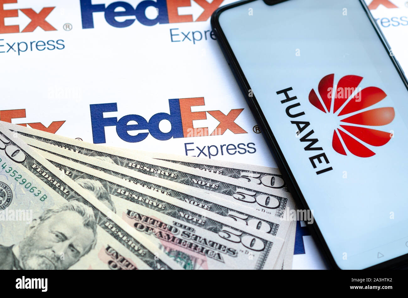 Huawei Smartphone mit Logo auf Paket FedEX logo mit US-Dollar. Diese konzeptuelle Foto zeigt USA-China trade Krieg und aktuelle Untersuchungen Stockfoto