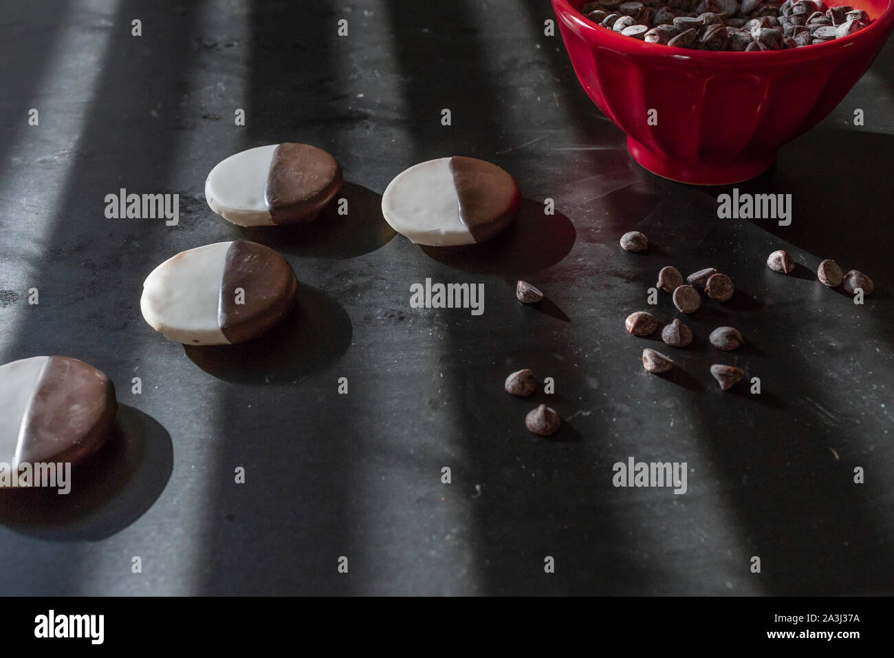 Schwarz und Weiß und Rot Schüssel cookies Chocolate Chips auf schwarz Tabelle Stockfoto