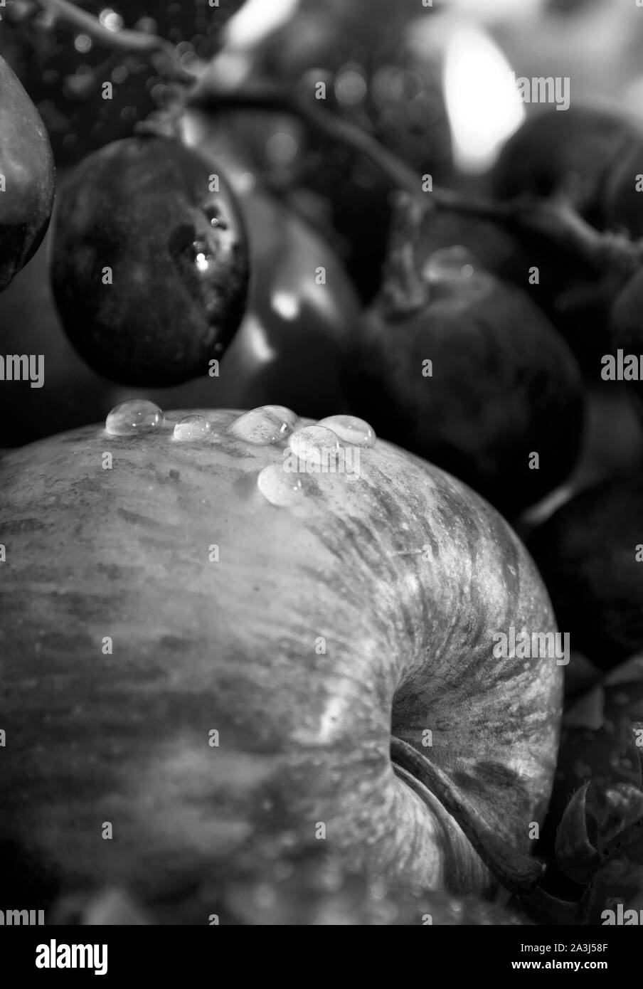 Nahaufnahme Foto von einem Apple mit einigen Tropfen und etwas Obst. Schwarz-weiß Foto. Stockfoto