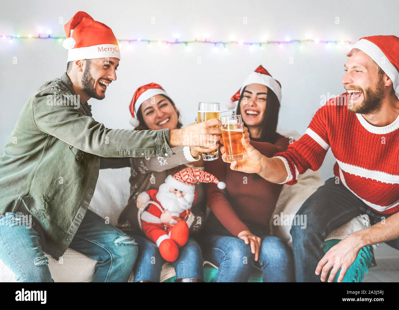 Gruppe der glücklichen Freunde jubeln und mit einem Bier für Weihnachtsfeier - Junge Menschen Spaß haben, trinken und gemeinsam genießen weihnachten urlaub Stockfoto