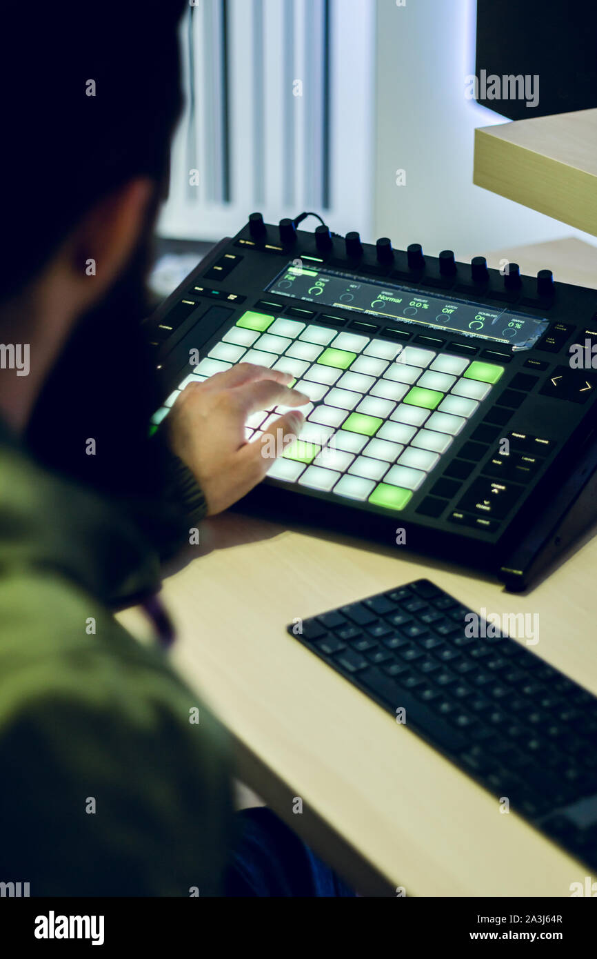 Bärtige junge Deejay produziert elektronische Musik in seinem Studio Stockfoto