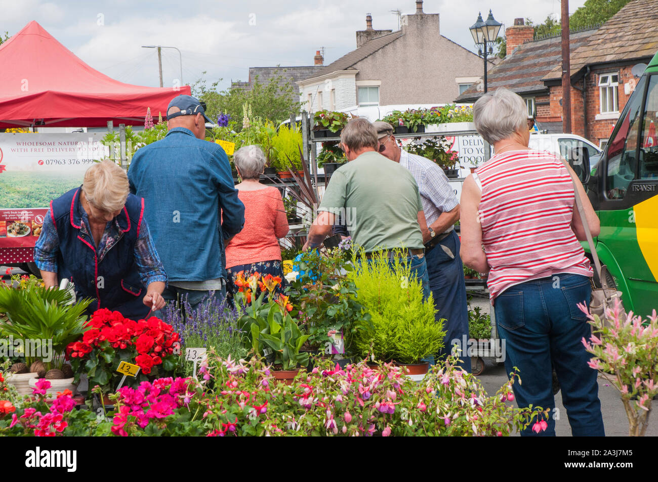 Die Mitarbeiter und Kunden an Blumen und Pflanzen auf ein Dorf Farmers Market am Great Eccleston Lancashire, England, Großbritannien Stockfoto