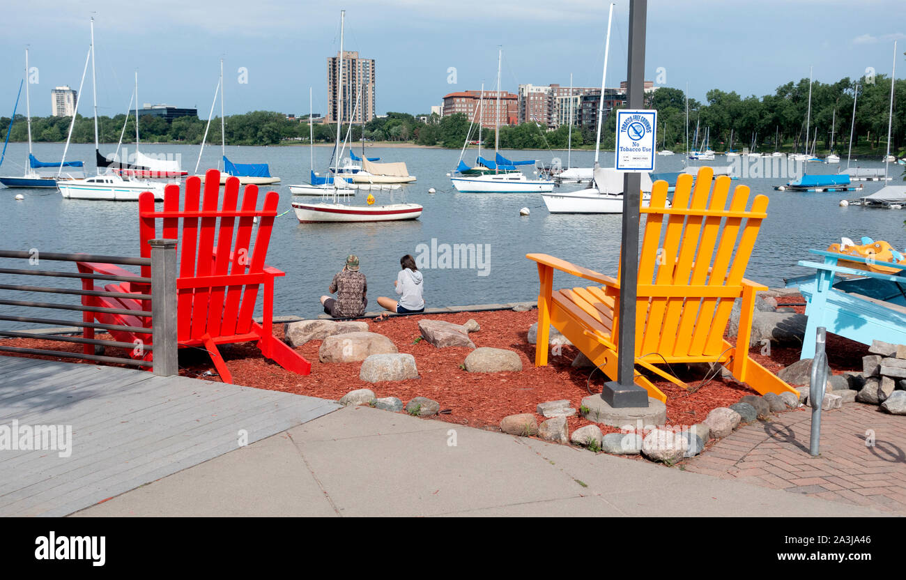 Schönen Lake Calhoun' Bde Maka Ska'Promenade mit Segelbooten, die von zwei riesigen hare' Stühlen eingerahmt. Minneapolis Minnesota MN USA Stockfoto