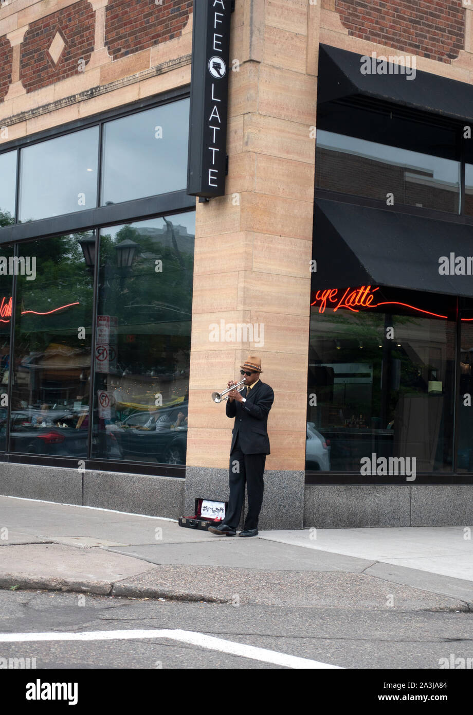 Schwarze Musiker spielen Trompete auf seinem üblichen Platz im Cafe Latte Ecke Grand und Victoria mit offenen Horn für Tipps. St. Paul Minnesota MN USA Stockfoto