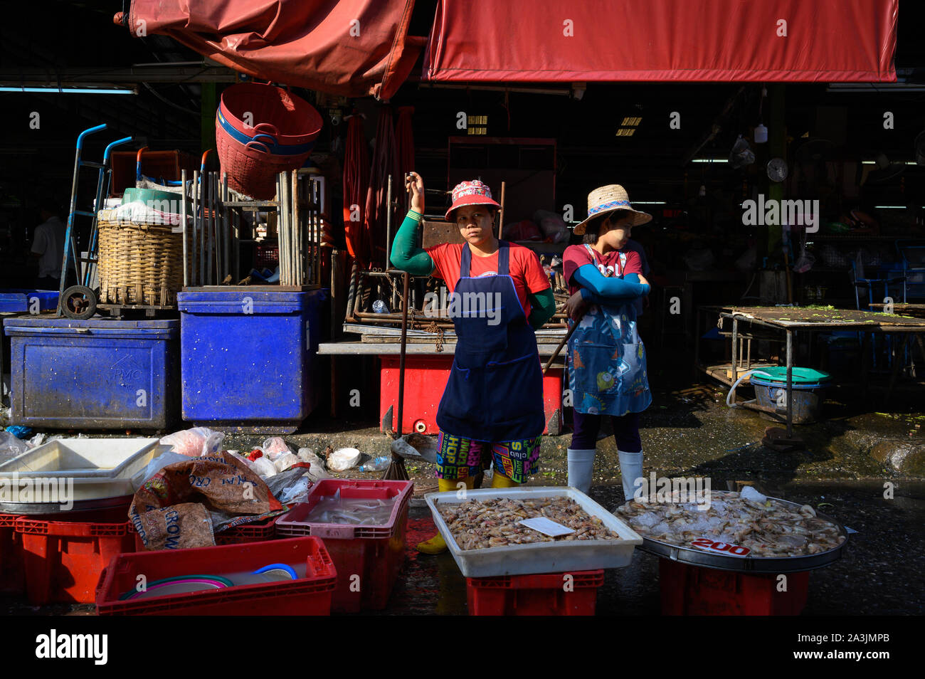 Arbeitnehmer, die im Sonnenlicht am Khlong Toey Market, Bangkok, Thailand stehend Stockfoto