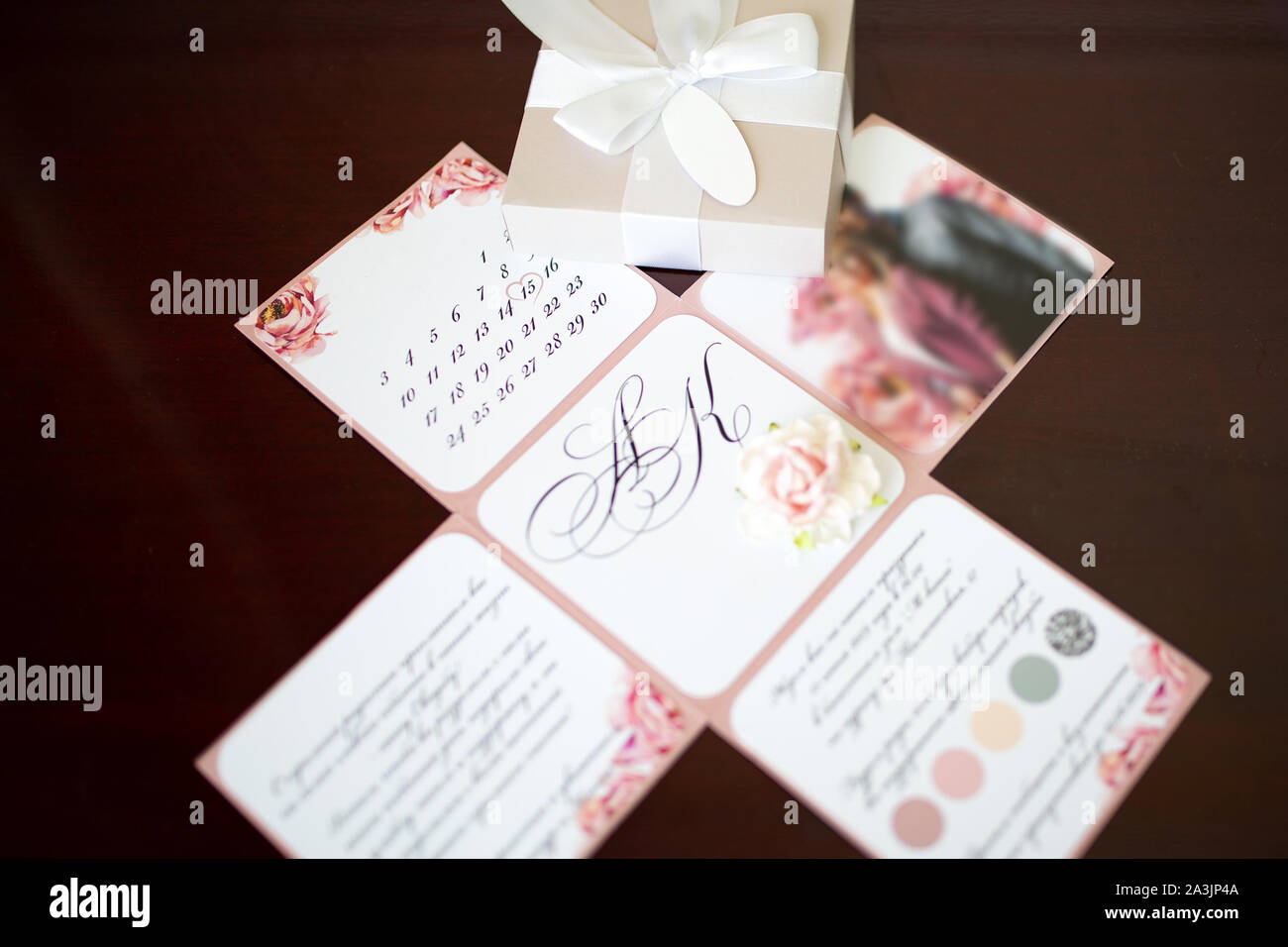 Close-up auf eine klappbare Einladung Hochzeit in Form eines Papiers, mit Foto, Text und ein Kalender mit dem Bild von Blumen. Einrichtung und Dekoration Stockfoto