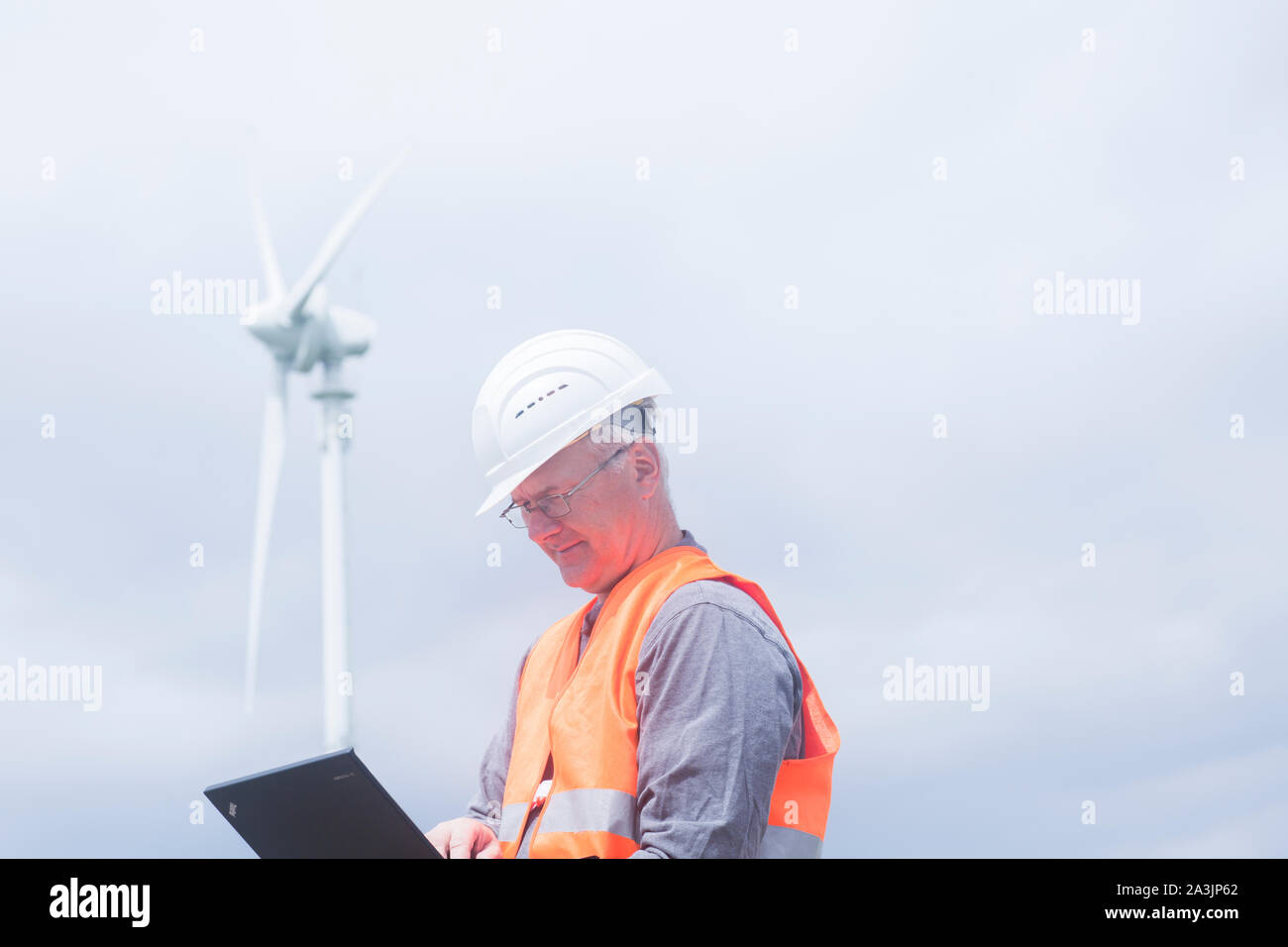 Ältere Energie Ingenieur vor einer Windmühle Stockfoto